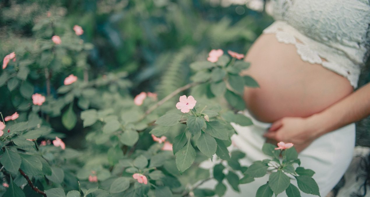 Kobieta w ciąży wśród kwiatów